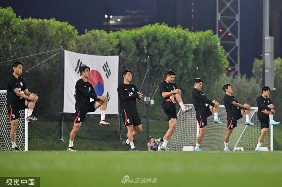 一名韩国队球员在夕阳下单独练习射门，皮球划出一道弧线，他的身影被拉得很长。