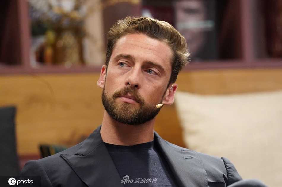 马尔基西奥在活动现场漫步，背景是熙攘的人群，他独自一人显得气定神闲，仿佛在喧嚣中开辟出一方属于自己的宁静空间。