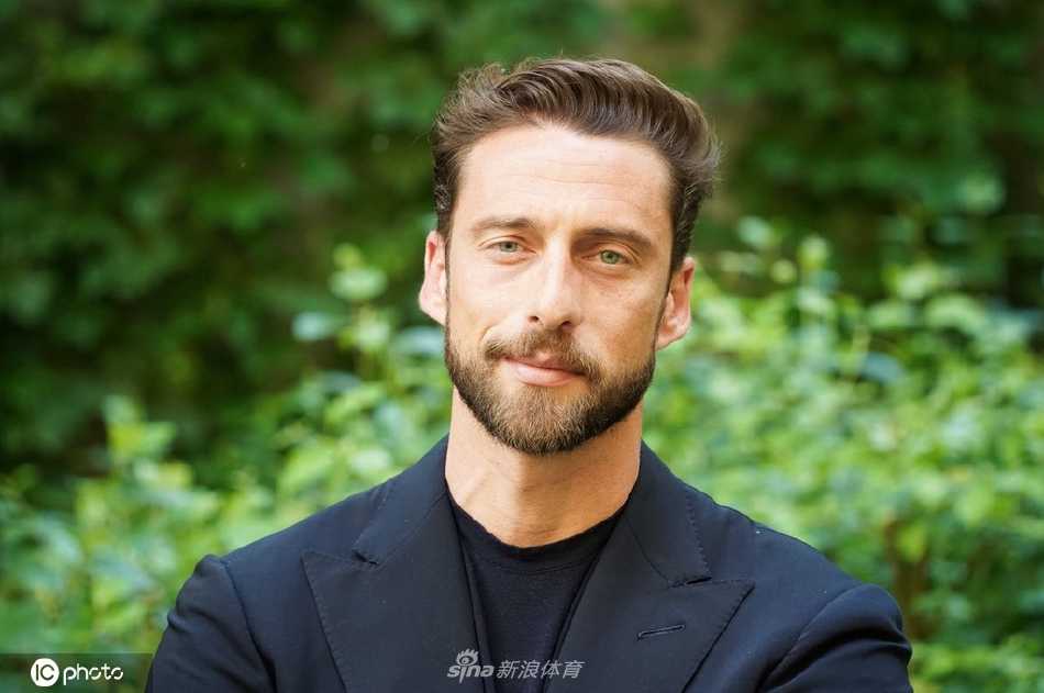 马尔基西奥侧耳倾听他人发言，神态专注而尊重，微蹙的眉头显示出他正在认真思考对方的话语。