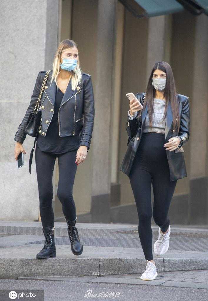 索菲娅墨镜遮面，与好友边走边聊，一身黑色紧身装扮勾勒出她超模的完美比例，一双笔直长腿无处安放。