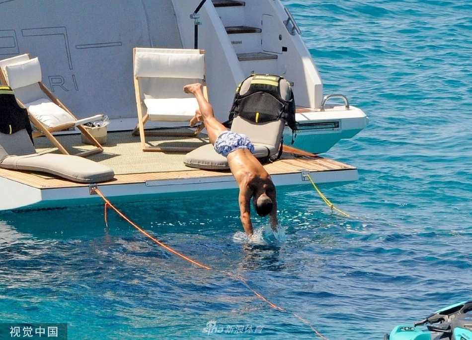 C罗半身浸在海水中，露出健硕胸肌与爽朗笑容，阳光在水面溅起璀璨光点