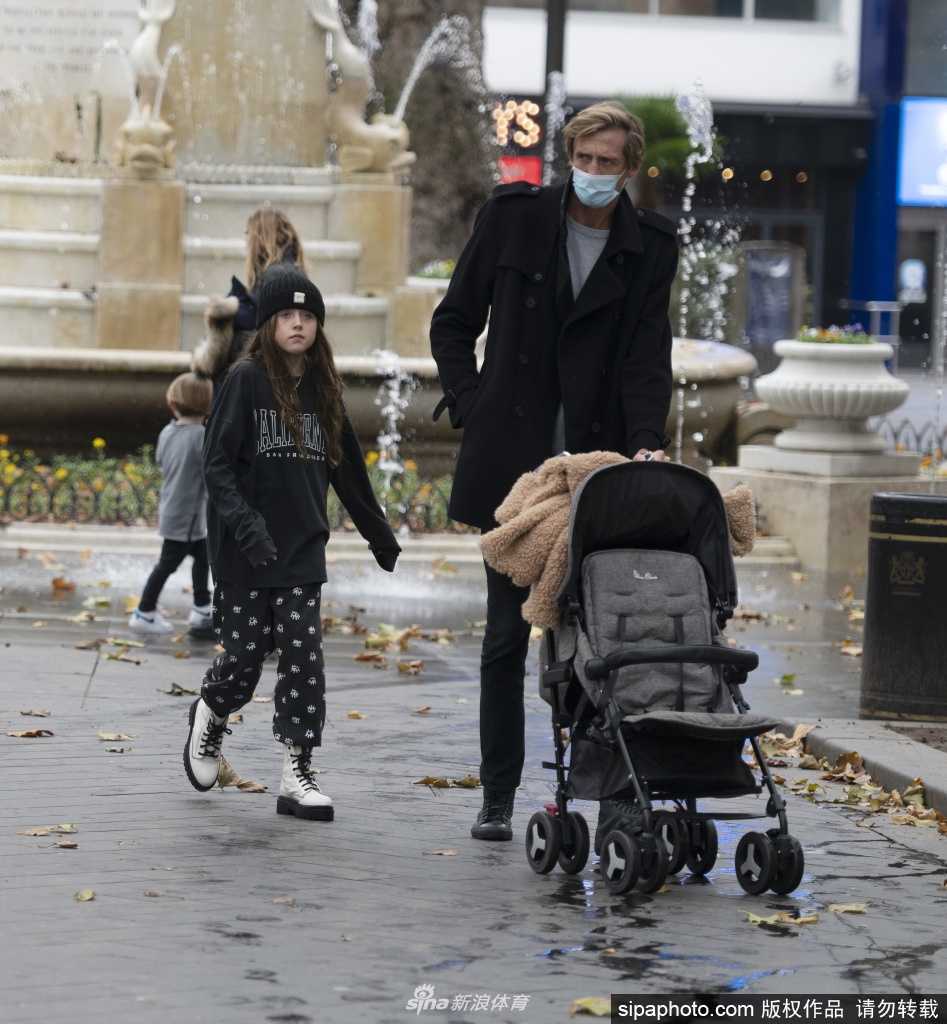克劳奇的爱妻阿比低头温柔注视着小女儿，脸上洋溢着宠溺的微笑，小家伙则紧紧牵着妈妈的手，迈着稚嫩的步伐，母女间的亲密互动在午后阳光下格外动人。