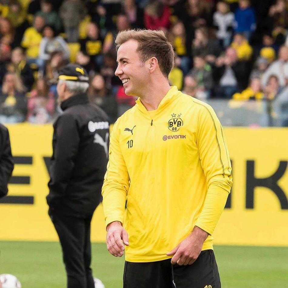 场边的多特工作人员也被球员们的轻松氛围感染，露出了会心的微笑。在即将到来的喧嚣面前，这一刻的宁静与和谐显得尤为动人。