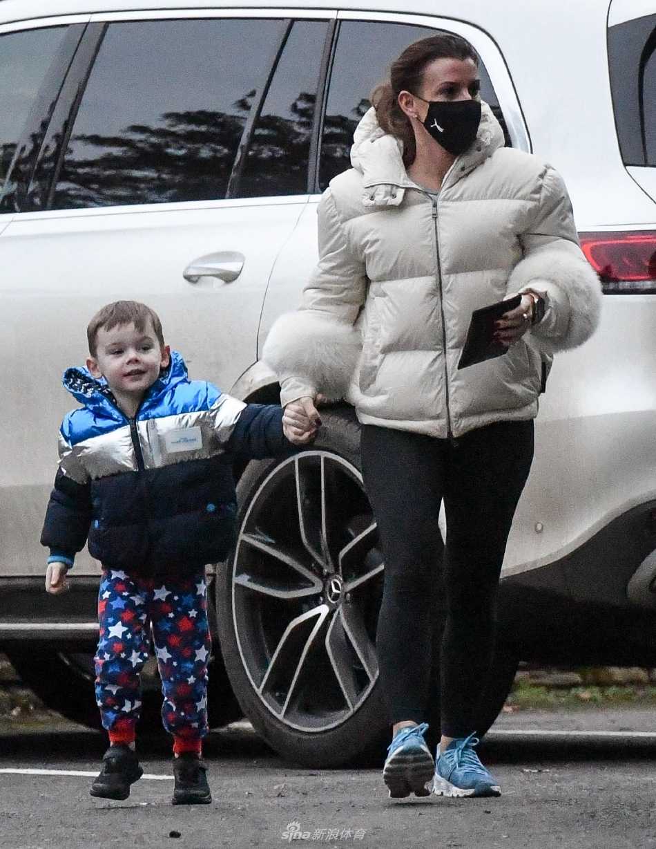 科琳侧身微笑注视着孩子，微风轻拂她的发丝，午后阳光为母子俩勾勒出金色的轮廓。
