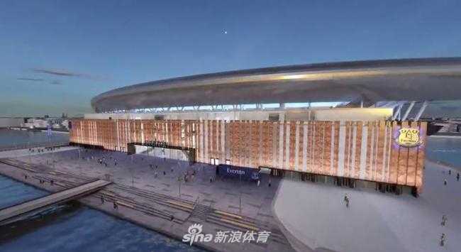 从空中俯瞰，这座崭新的球场像一艘停泊在默西河畔的钢铁巨轮，其流线型的屋顶在阳光下闪耀着金属光泽，与周围的 historic docks 工业遗迹完美融合，展现出历史与现代的碰撞。