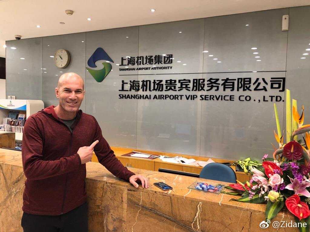 阳光洒在杭州某小区的空地上，齐达内像个好奇的孩子，搬了个红色小板凳坐在一旁，目不转睛地盯着牌桌，神情专注而有趣。