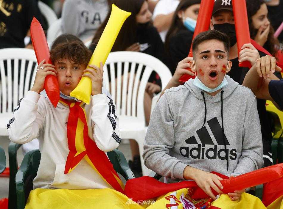 fervor en la plaza el pequeño pueblo español se arrodilla por la victoria en la semifinal de la eurocopa Primer plano de un grupo de amigos abrazados y de rodillas, con los ojos cerrados y expresiones de angustia y súplica, durante el lanzamiento decisivo para España.