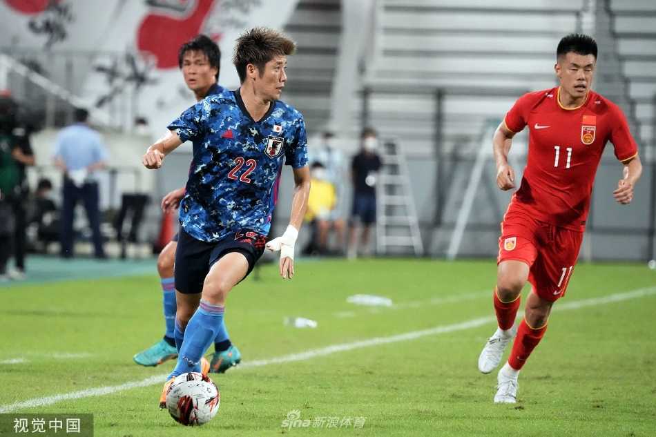 中国队球员谭龙在对方禁区前沿背身护球，遭遇日本队两名后卫的夹击防守