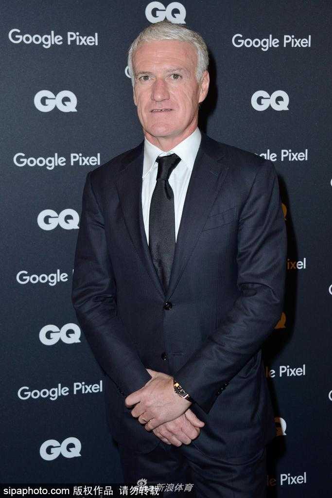 德尚身穿精致深色西装现身GQ颁奖礼红毯，面带微笑向镜头挥手致意，尽显法兰西冠军教头的儒雅风范