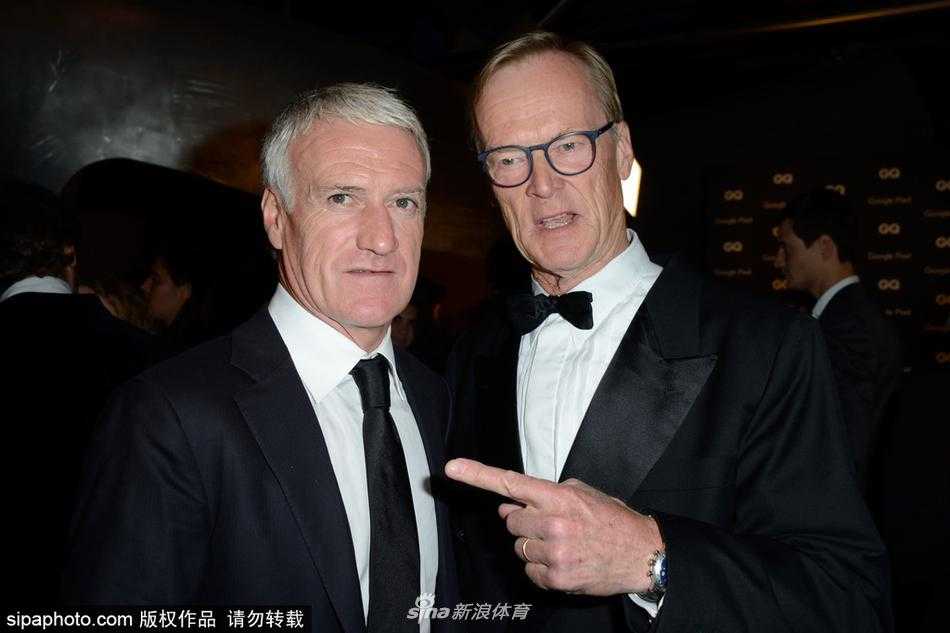 德尚在GQ年度颁奖典礼上单手整理西装袖口，神情专注而自然，举手投足间散发出成熟男性的魅力与时尚品味