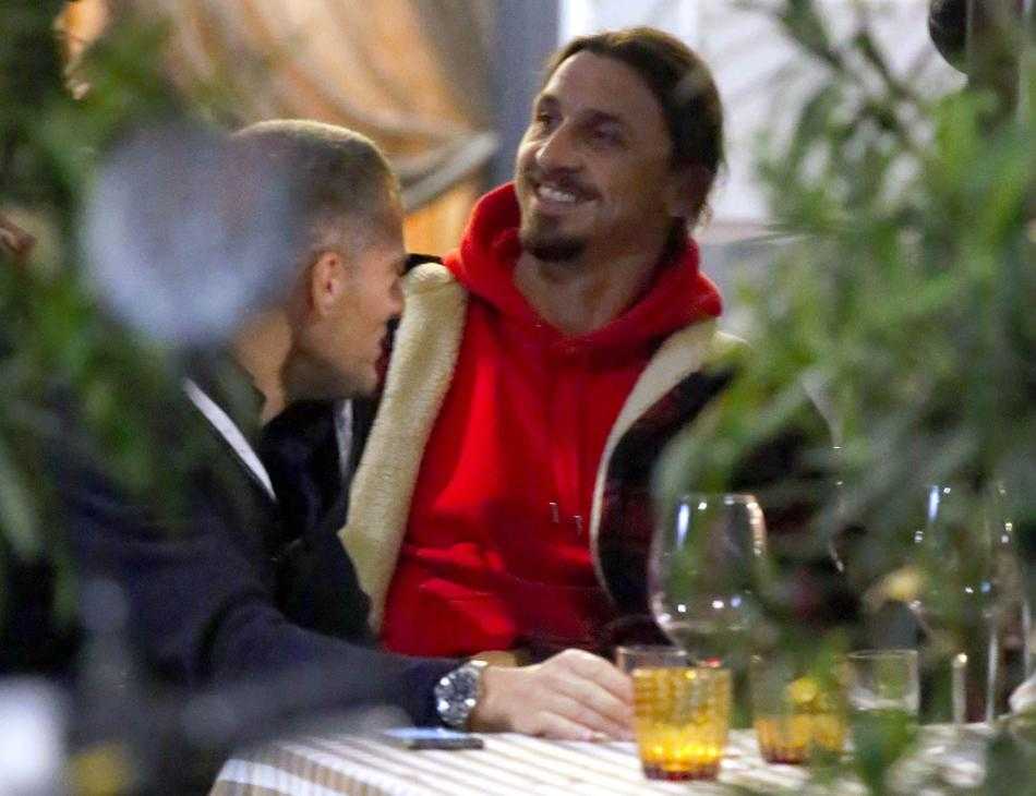 伊布与球迷的合影中，他微微俯身，侧耳倾听球迷的话语，脸上带着礼貌的微笑，右手轻搭在球迷肩头，这一刻他不是球场上的霸主，而是一位友善的巨人，与米兰城的爱意在此刻具象化。
