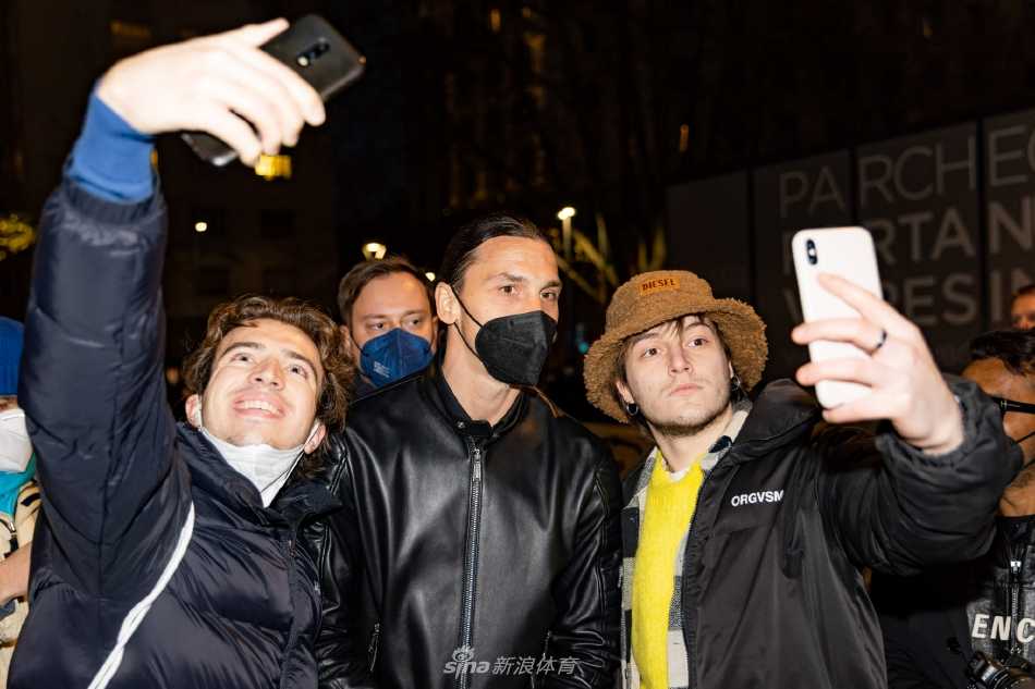 伊布面露迷人微笑，俯身与一位小球迷击掌，画面充满温暖与关爱