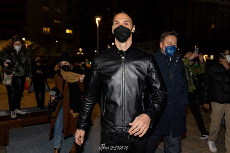 伊布身着深色大衣抵达现场，自信挥手向人群致意，王者气场笼罩全场