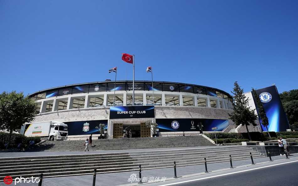 利物浦球员在伊斯坦布尔的沃达丰公园球场训练，背景是博斯普鲁斯海峡的迷人夜景，灯光与海面交相辉映，气氛宁静而充满期待。