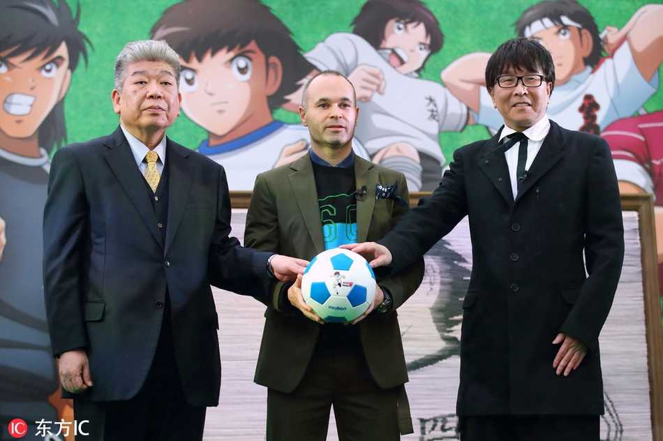 漫画原作者高桥阳一满脸笑意，将这件承载着无数少年梦想的球衣递到伊涅斯塔手中，两位在不同领域创造“足球梦”的人，在此刻交汇。
