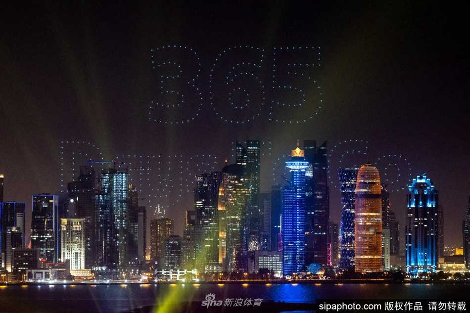 深邃的夜幕下，数百架无人机如同被施了魔法的萤火虫，精准地拼凑出 rotating 的卡塔尔世界杯会徽，光影流转间，仿佛金色的希望之种在夜空中生根发芽。