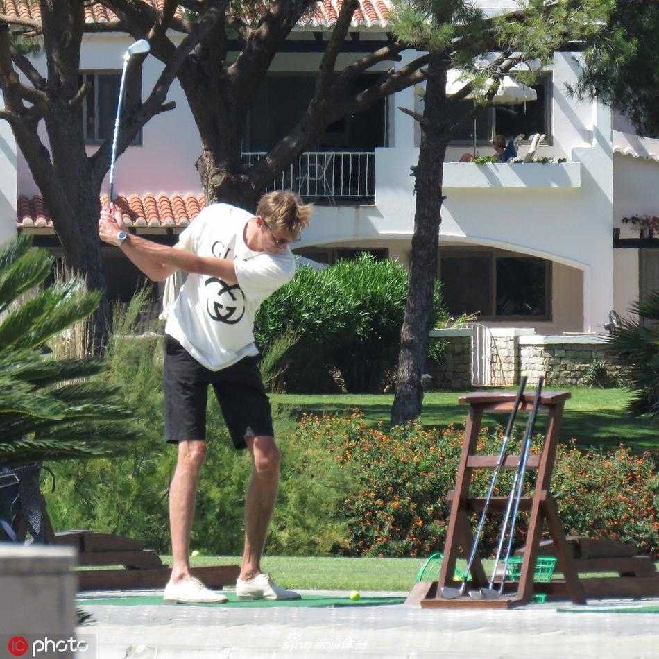 艾比·克兰茜身着时尚的黑色露脐上衣与高腰长裙，脚踩高跟鞋，优雅地推着婴儿车，克劳奇则在她身后温柔注视，画面充满了甜蜜与默契。