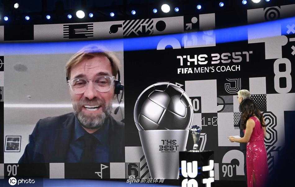 克洛普手捧FIFA最佳教练奖杯，对着镜头露出标志性的灿烂笑容，背后的利物浦队徽熠熠生辉，仿佛在诉说着这支红色军团重新登顶英超的荣耀。