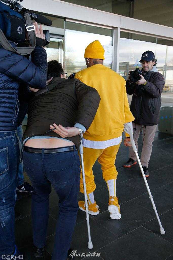 内马尔在人来人往的机场大厅中拄着双拐，低头沉默，沉重的脚步似乎不仅是因为脚上的伤势，更因为内心的煎熬