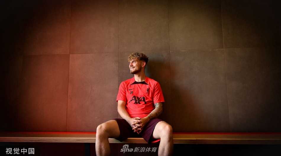 埃利奥特在绿茵场上带球飞奔，红色的身影在球场灯光下显得格外醒目，充满了速度与力量感。