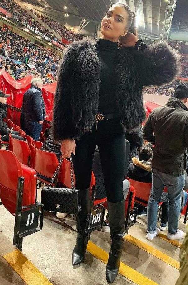 霍莉穿着时尚的低胸装漫步在都市街头，脸上洋溢着自信的笑容，这位模特显然很享受成为舆论焦点带来的感觉