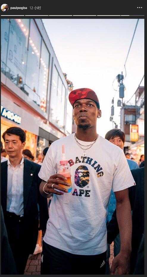 博格巴在活动后台与友人交谈，他侧身面对镜头，精心打理的发型与夸张的耳饰格外抢眼。他身穿一件剪裁利落的黑色外套，内搭的T恤上印有个人专属logo，细节处彰显着这位足坛巨星对自我品牌的经营与热爱。