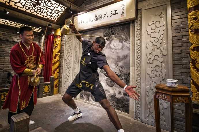 活动尾声，博格巴手持一把写着“POGBA”的白色折扇，对着镜头做出搞怪的表情，背景是成都的古色古香的建筑，东西方文化的碰撞在这一刻显得格外生动有趣。