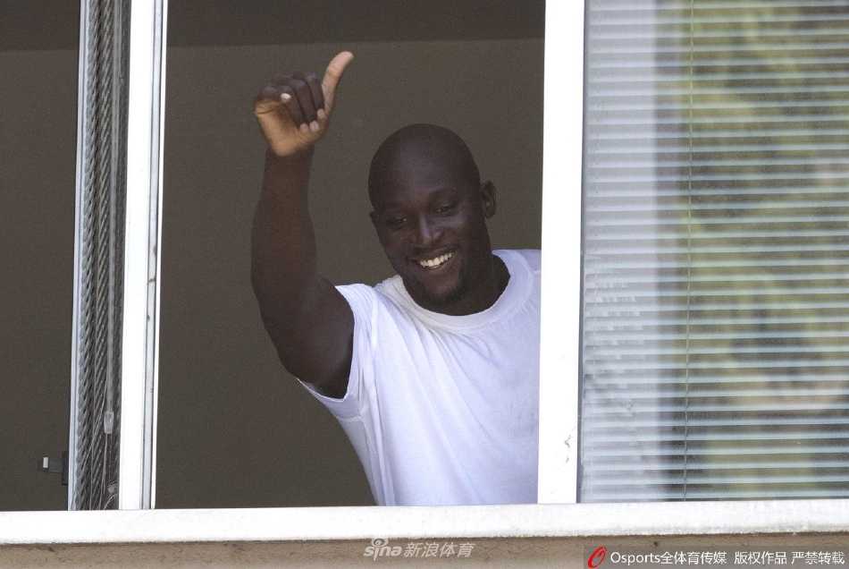 在安保人员的护送下，卢卡库步行穿过人群，他微微低头与一位小球迷击掌，画面充满了铁汉柔情的温暖瞬间。