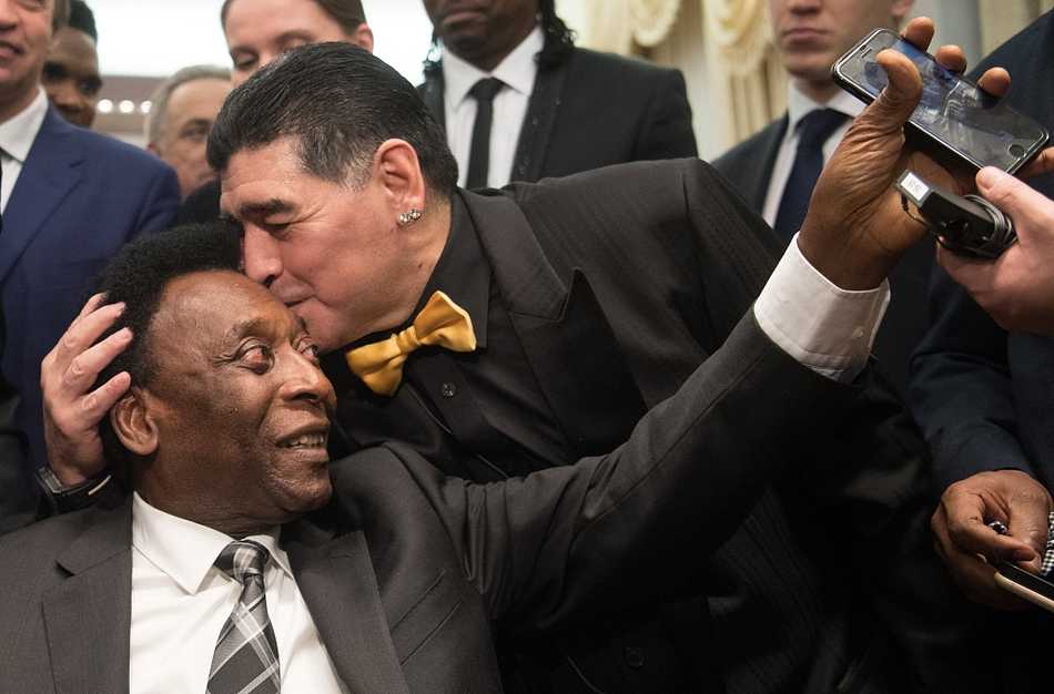 贝利和马拉多纳共同出席颁奖典礼，两人身着正装，并肩站立。马拉多纳手捧奖杯，贝利则在一旁轻轻鼓掌，神情里既有欣慰也有祝福。这是两代球王共同享有的荣耀时刻，也是足球历史长河中最珍贵的画面之一。