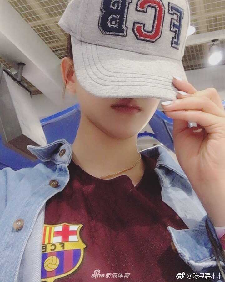 陈昱霖手持一条巴萨围巾，站在一家高级餐厅的露台上，背景是迷人的城市夜景，围巾的红蓝色在夜色中格外醒目，仿佛在异国他乡找到了归属感