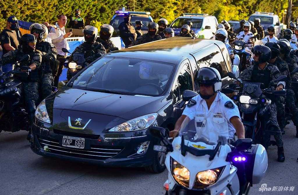 披着阿根廷国旗的马拉多纳灵柩静静安放在总统府玫瑰宫中央，棺木上覆盖着他挚爱的蓝白色旗帜与那件象征着荣耀与不羁的10号球衣，一旁摆放着复制的大力神杯，仿佛他只是在绿茵场上小憩。