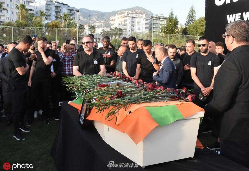 巨大的苏拉尔遗像放置在草坪中央，照片中的他目光如炬，仿佛仍在凝视着这片他深爱的绿茵场。队友们低头默哀，与他做最后的告别。