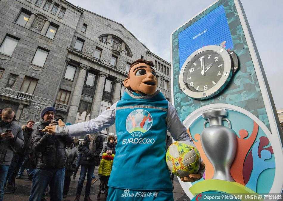 热情奔放的“斯基尔茨”紧紧拥抱一位戴着帽子的市民，被拥抱的市民笑得合不拢嘴，周围的人群也被这欢乐的气氛感染，纷纷鼓起掌来。