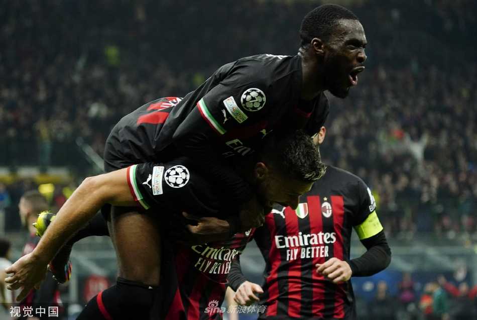 吉鲁与克鲁尼奇激情相拥庆祝，后者打入了锁定胜局的第二球，两人身后是欢呼的队友和沸腾的看台。