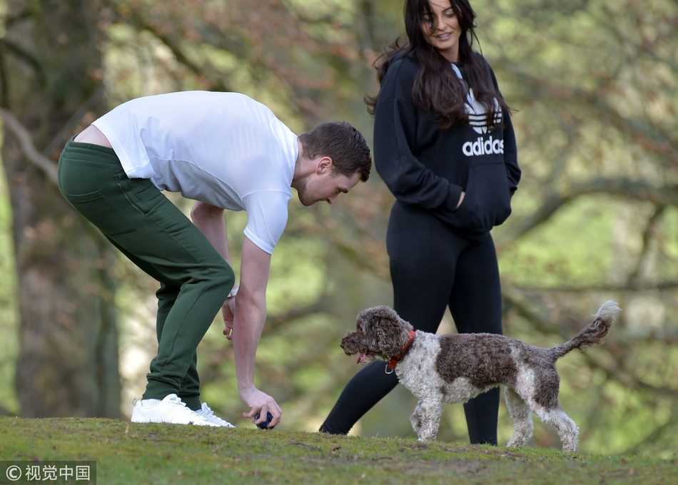 在妹妹的陪伴下，亚当-约翰逊牵着爱犬在街头散步，他刻意压低帽檐，似乎想躲避外界的目光，但宽松的运动服依然掩盖不住他发福的身形和落寞的神情。