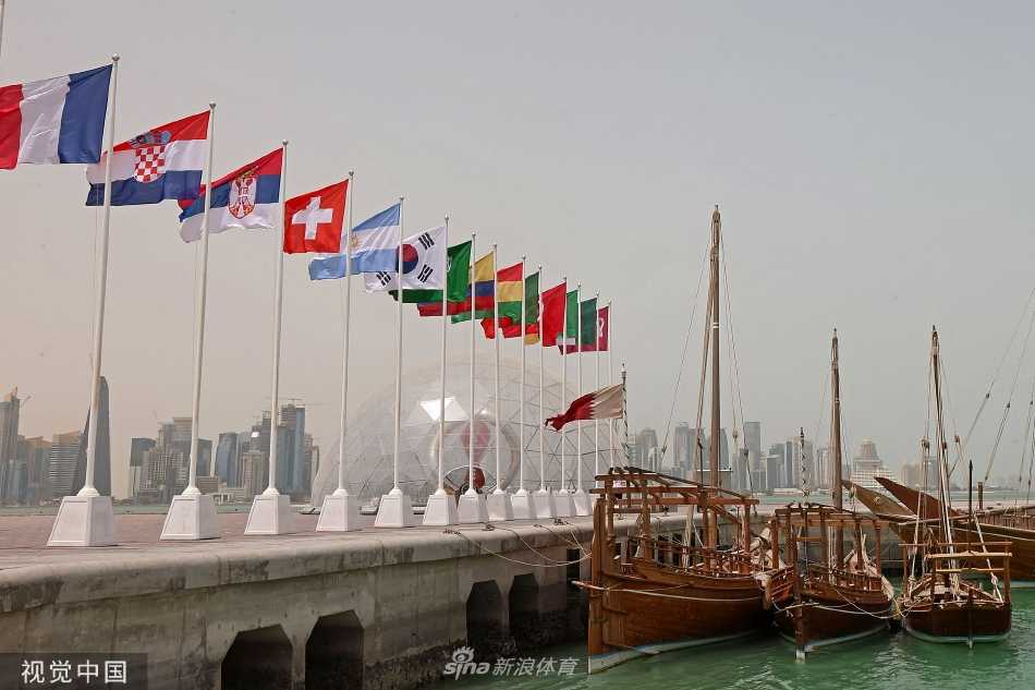 多哈街头五彩斑斓的足球主题艺术涂鸦墙前，几位当地青年正在驻足欣赏，艺术与足球的结合让城市充满了活力与创意。
