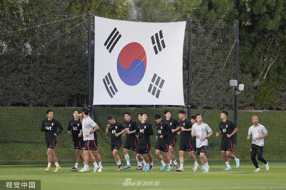 主教练保罗·本托站在训练场中央，神情专注地向围绕他的球员们讲解战术要点，队员们凝神倾听
