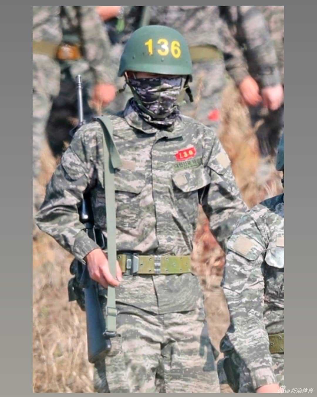 迷彩服下是晒得黝黑的皮肤，孙兴慜正一丝不苟地整理装备，为下一轮训练做准备