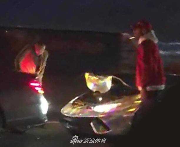 事故现场的另一个角度，清晰地展示了兰博基尼左侧车身的惨状，车门凹陷，碳纤维材质的侧裙板碎裂，露出了内部复杂的机械结构，如同一头受伤倒地的猛兽。