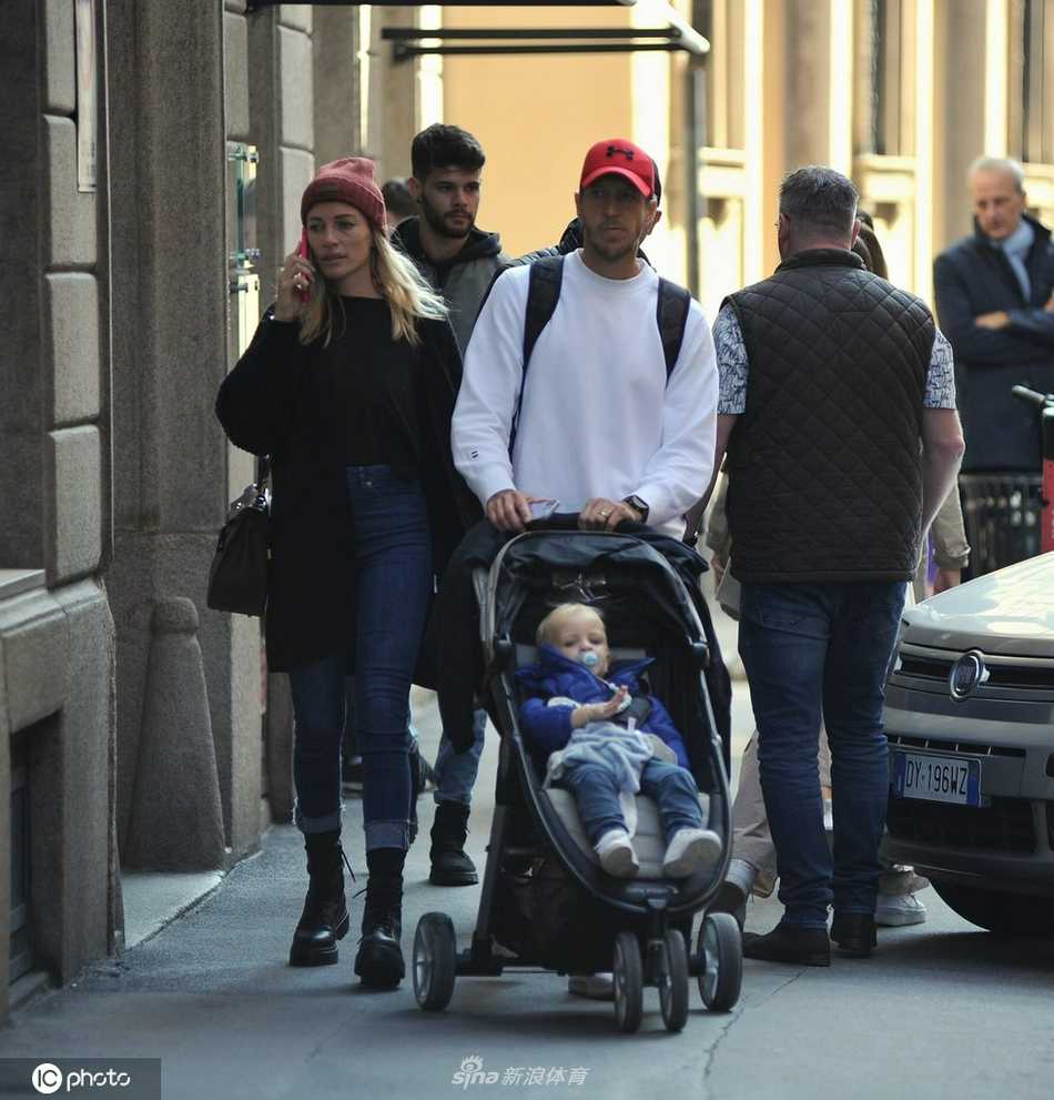 安布罗西尼与爱妻在米兰街头并肩而行，两人面带微笑，眼神中满是岁月沉淀后的默契与温情，仿佛在低声细语地分享着生活的点滴。