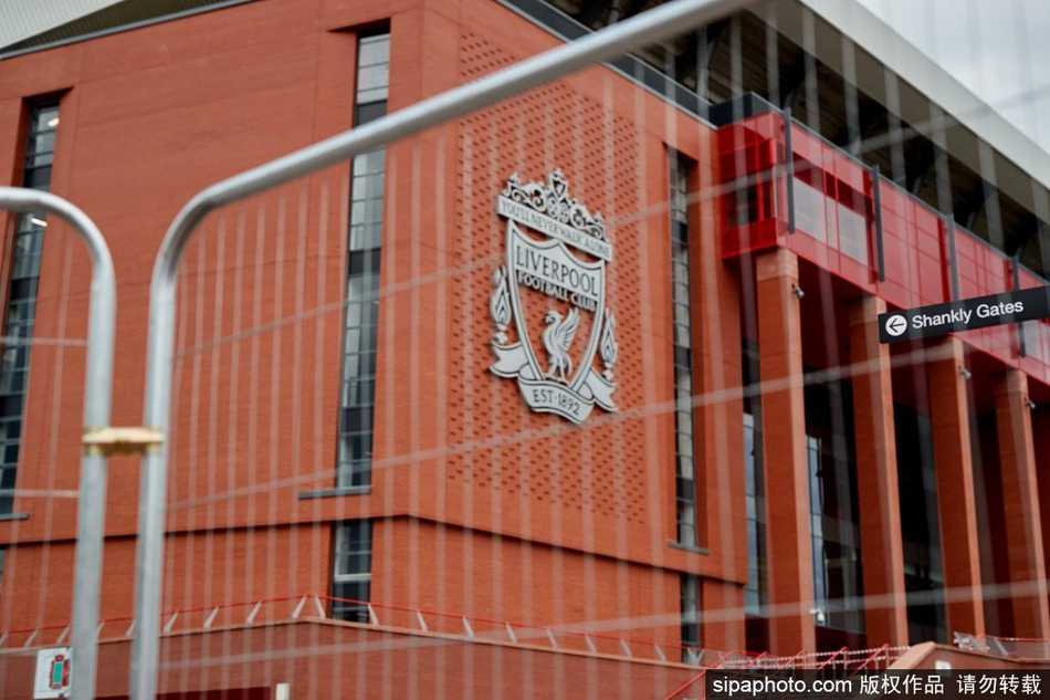 安菲尔德空旷的看台上，铺满了巨幅的‘This Is Anfield’标语和球员旗帜，昔日喧嚣的KOP看台此刻静默却充满力量，仿佛在等待一场即将到来的盛大狂欢。