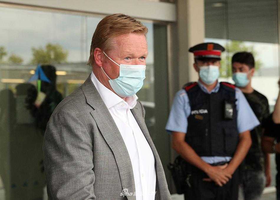 科曼身着一丝不苟的深色西装，面带微笑走出机场闸口，他的眼神中既有重返巴塞罗那的喜悦，也透露出接手重任的坚毅与笃定。
