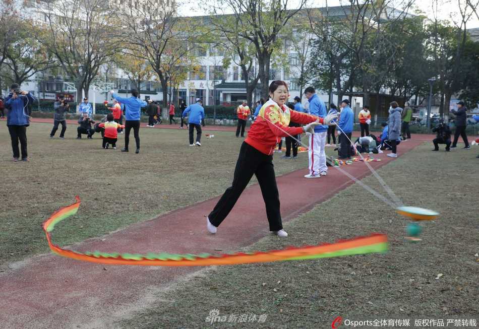 两位空竹高手正在默契配合，一条长长的彩带龙随着空竹的旋转腾空而起，在阳光下划出绚丽的金色弧线，龙身翻飞，与表演者自信的笑容相映成趣，场面既壮观又充满喜庆。