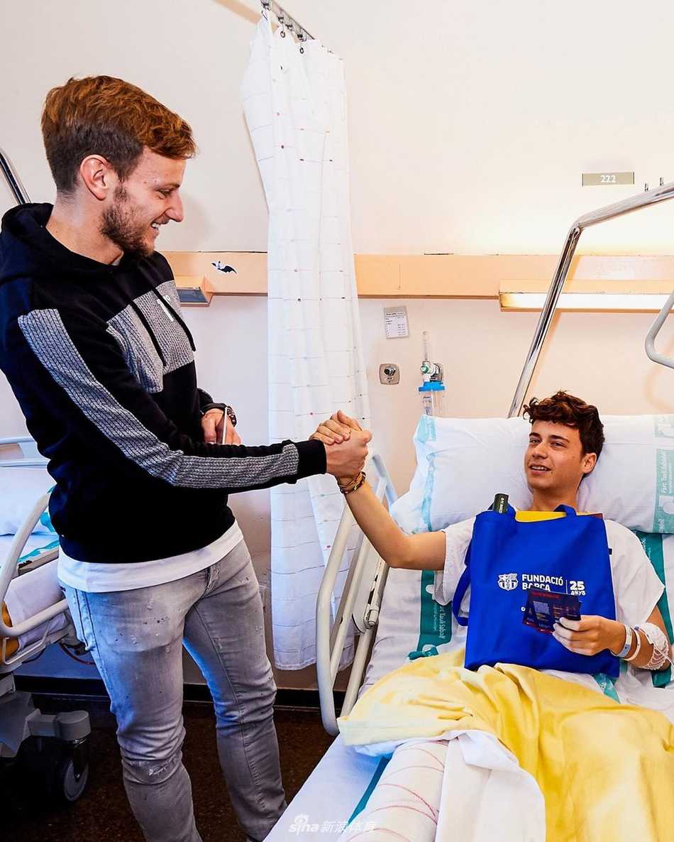 球员微笑着单膝跪地，双手递出俱乐部的吉祥物玩偶，孩子伸出小手接过这份珍贵的礼物，眼中闪烁着惊喜与喜悦的光芒。