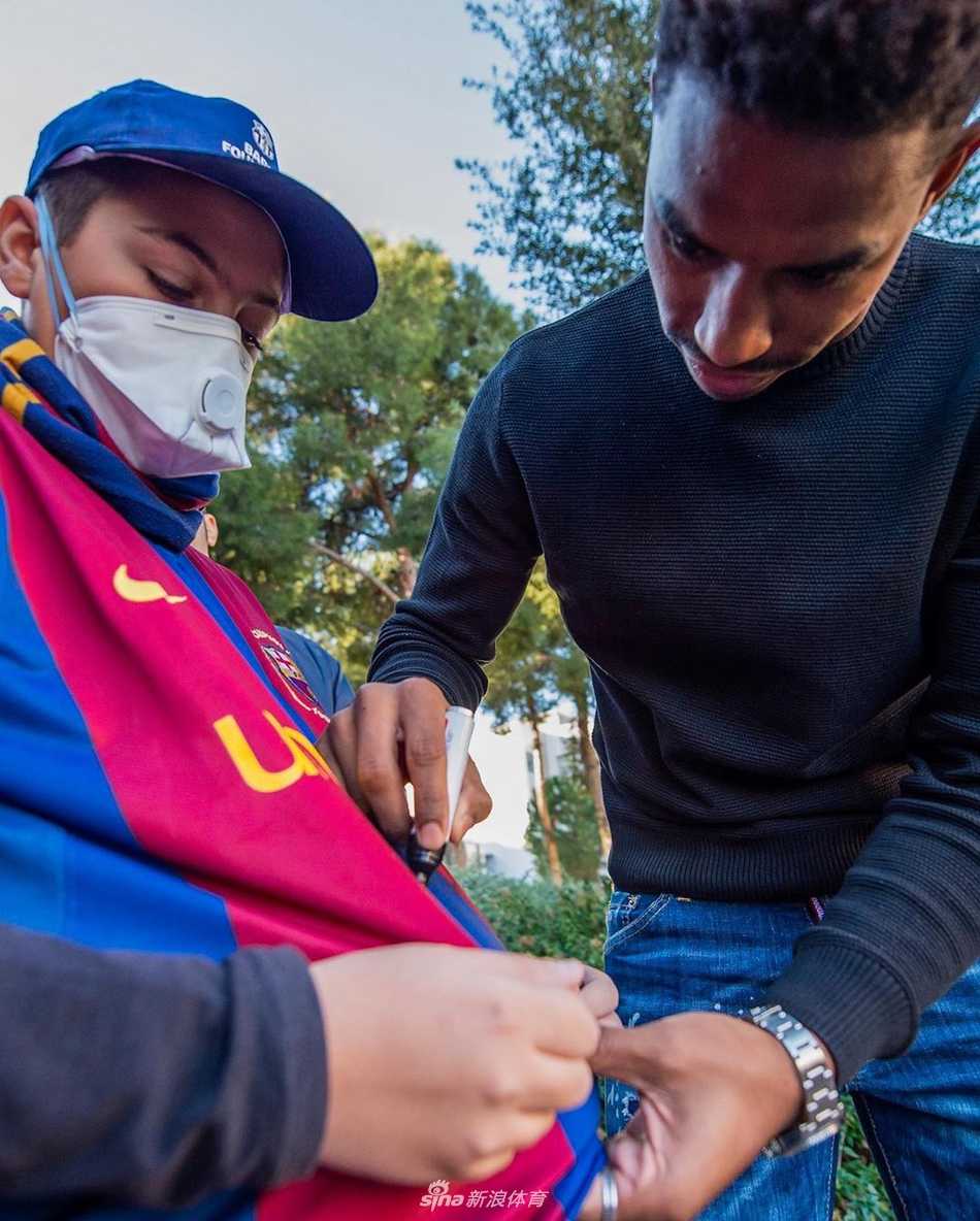 球员轻轻握住病童纤细的小手，仿佛在进行一场男子汉间的约定，鼓励他像战士一样勇敢，早日康复重返绿茵场。