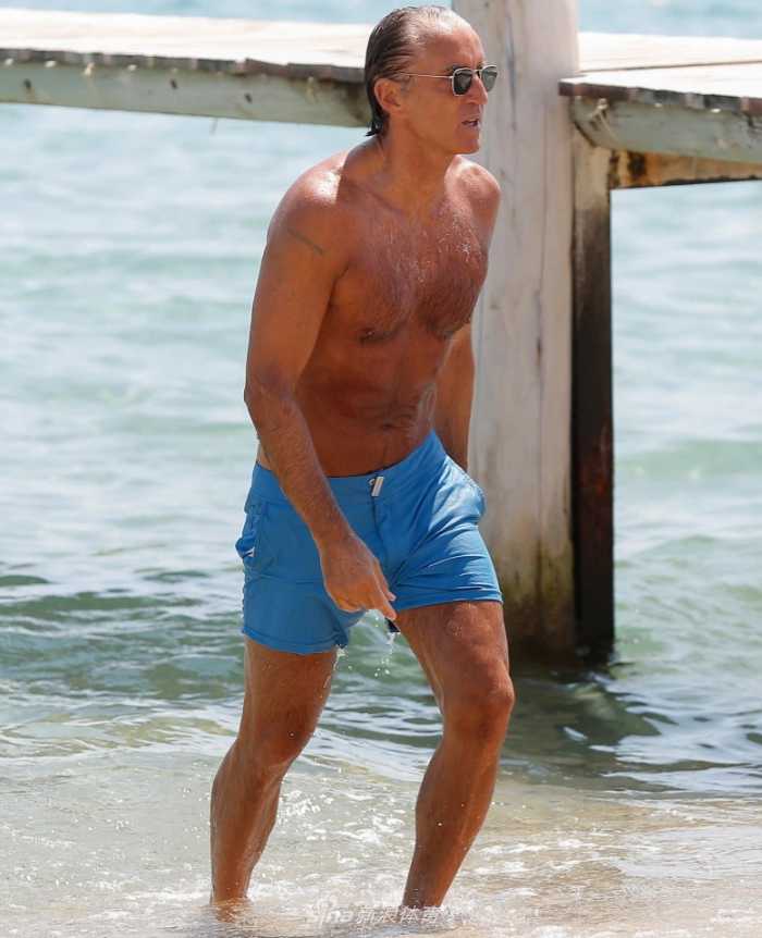 罗伯托·曼奇尼赤膊上阵，古铜色的皮肤下胸肌与腹肌清晰分明，他闭目享受阳光，仿佛时间在他54岁的身体上按下了暂停键。