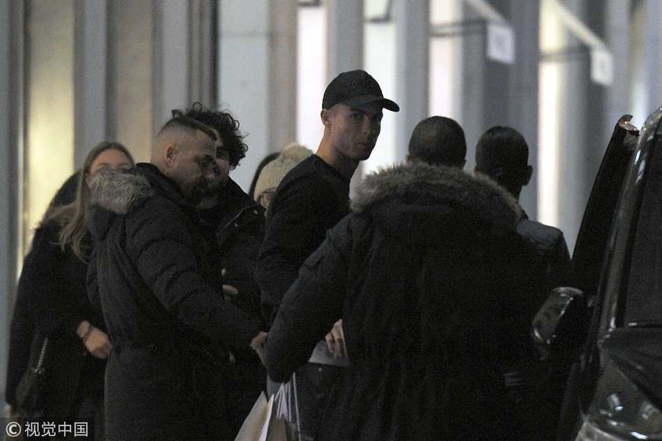 C罗专注地审视一件挂起的时尚男装，仿佛在球场上观察对手一样认真，尽显其对生活品质的追求。