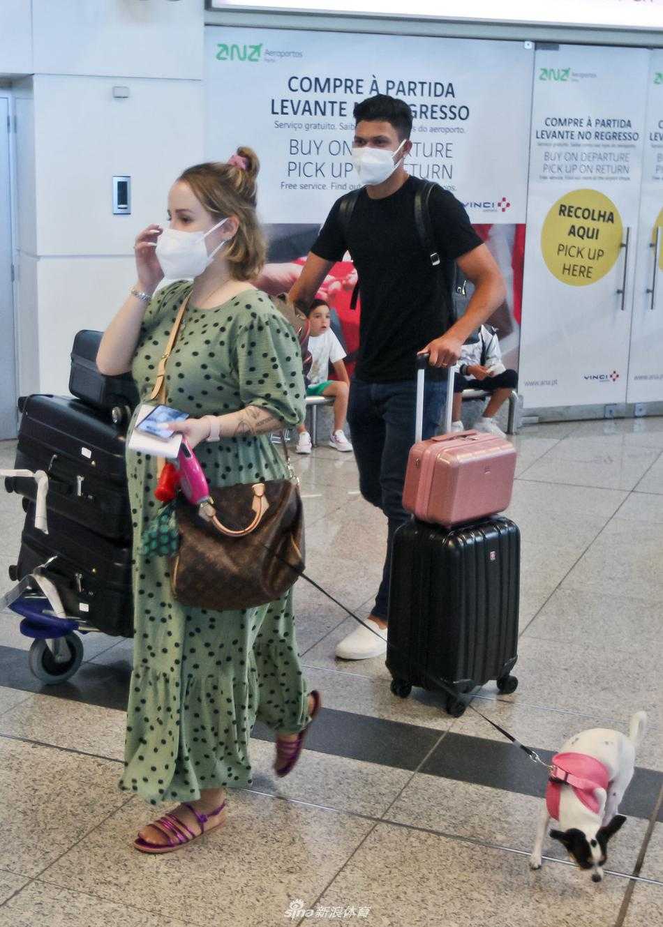 训练基地的围墙边，奥塔维奥侧身对着镜头，耳朵上戴着现代感十足的蓝牙耳机，似乎还在回味假期最后一段音乐旅程。他身穿深色休闲上衣，肩上的背包带勒出放松的姿态，神情专注地准备踏入基地大门，开启新赛季的备战。