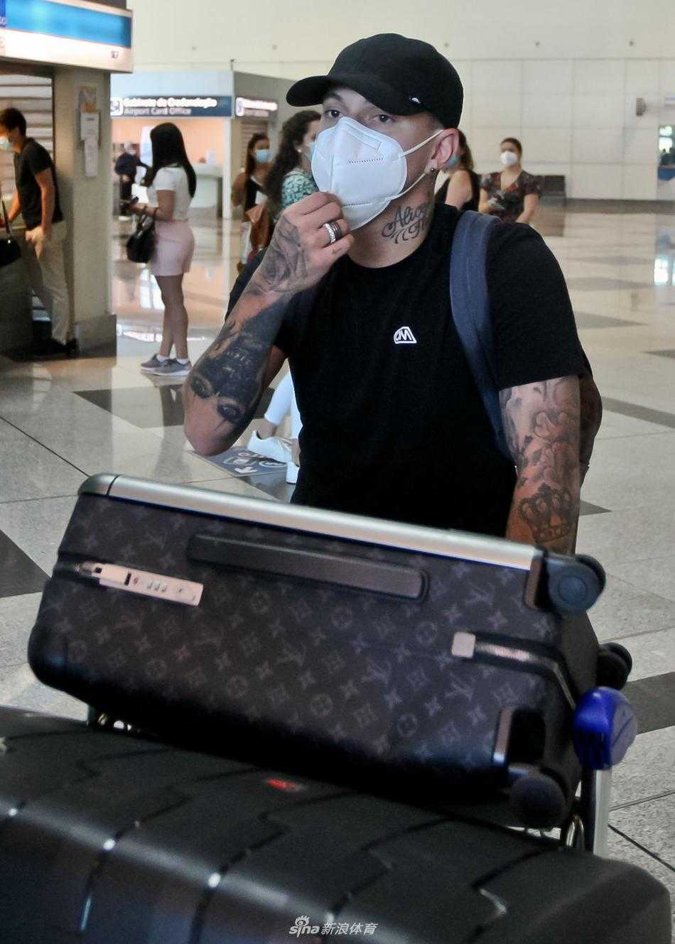 在训练基地外围的铁栏杆旁，埃文尼尔森被镜头捕捉到低头调整背包的瞬间。这一瞬间充满了生活的真实感，仿佛任何一个准备上班的年轻人，但背景中的波尔图队徽装饰物却悄悄暗示着，他即将奔赴的是一片充满荣耀与战斗的绿茵场。