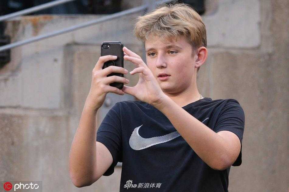 巴伦开怀大笑，似乎被场上的有趣瞬间逗乐，身后球迷也面带笑容